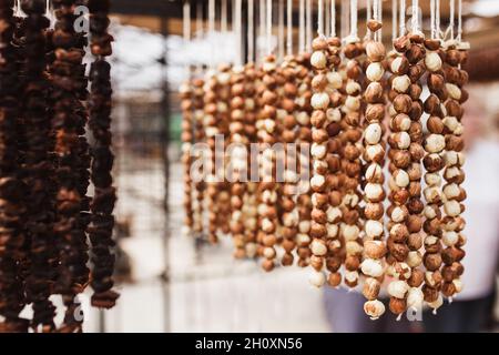 La douceur géorgienne Churchkhela - un sucre traditionnel en forme de saucisse fait en trempant une longue série de noix dans un mélange de farine, de sucre et de badagi - Banque D'Images