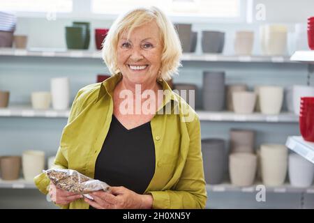 Une femme heureuse en tant que client magasiner dans le centre du jardin ou dans la quincaillerie Banque D'Images