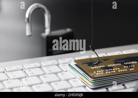 Cartes de crédit bancaires en plastique et crochet à poissons sur le clavier de l'ordinateur Banque D'Images