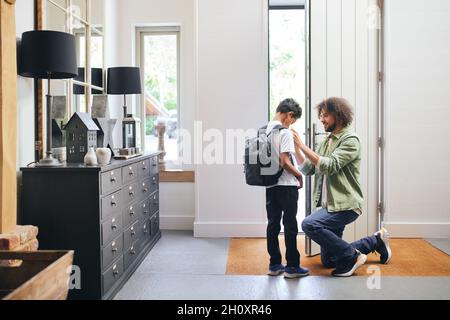 Père aider son fils à se préparer à l'école Banque D'Images