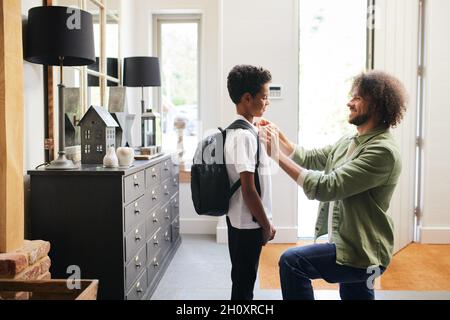 Père aider son fils à se préparer à l'école Banque D'Images