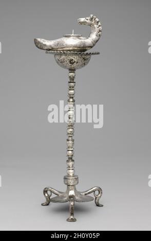 Lampe et support, fin 300.Byzance, Syrie?, début de la période byzantine, fin du 4ème siècle.Argent ; hors tout : 9.2 x 16 x 7 cm (3 5/8 x 6 5/16 x 2 3/4 po).De nombreuses lampes à huile de formes et de tailles diverses ont survécu à la fin de la période romaine et au début de la période byzantine.La plupart servaient une fonction utilitaire de base et étaient simplement façonnés d'argile ou de bronze.Cependant, quelques exemples plus élaborés, comme celui-ci, ont survécu en argent.Dotée d'une élégante poignée à tête bombée, cette lampe a été conçue pour s'adapter au socle voisin, offrant ainsi à son propriétaire une grande flexibilité de fonctionnement. Banque D'Images