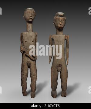 Paire de figures, fin du XIXe siècle-début du XXe siècle.Afrique centrale, République démocratique du Congo ou République centrafricaine (très probablement), éventuellement Monzombo.Bois et fer; partie 1: 145 x 31.8 x 23.2 cm (57 1/16 x 12 1/2 x 9 1/8 po.); partie 2: 145 x 26.8 x 23.3 cm (57 1/16 x 10 9/16 x 9 3/16 po.).L'histoire des migrations et des assimilations successives de la région d'Ubangi a entraîné de nombreux échanges de croyances religieuses et de pratiques rituelles.Malgré certains traits stylistiques, y compris les visages en forme de cœur et la coiffure à crête du mâle, cette figure avec sa paire de femmes est différente de n'importe quel autre dans Banque D'Images