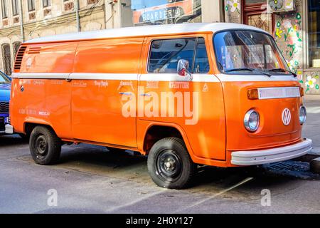 Bucarest, Roumanie, 2 janvier 2021 Old Vivid orange hippie Volkswagen Kombi van garé une rue dans une journée ensoleillée Banque D'Images