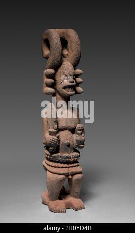 Figurine de sanctuaire (Ikenga), probablement au début des années 1900.Afrique, Afrique de l'Ouest, Nigeria, Igbo Carver.Bois, matières organiques et raphia; total: 74.5 x 18 x 20 cm (29 5/16 x 7 1/16 x 7 7/8 po).Cette figure assise d'un homme tenant un cutlass et un crâne humain inversé est un objet culte appelé ikenga, associé à la réalisation et au succès.Debout au centre du sanctuaire personnel d’un homme, la sculpture reçoit des prières et des sacrifices en échange de l’orientation des ancêtres.Une adresse élaborée comprenant deux extensions en forme de corne renforce la préoccupation du culte par rapport à la masculinité, tandis que l’incis faciale Banque D'Images