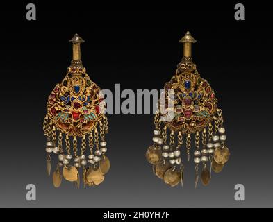 Paire de boucles d'oreilles avec Vishnu Riding Garuda, 1600s ou 1700s.Ensemble d'or avec pierres précieuses et semi-précieuses; ces boucles d'oreilles ont été faites pour accrocher sur de grandes sculptures de bronze de déités adorées dans les temples népalais.Les artisans népalais ont excellé dans l'incrustation détaillée de bijoux pour représenter des images de figuration complexes.Ils ont formé des fils d'or dans un cadre, puis ont inséré des pierres polies dans les espaces, maintenus en place avec un adhésif.Le Vishnu à quatre armes est fait de saphirs; son mont l'aigle-homme semble être fait de carnélien et de spinelle avec des ailes de turquoise. Banque D'Images