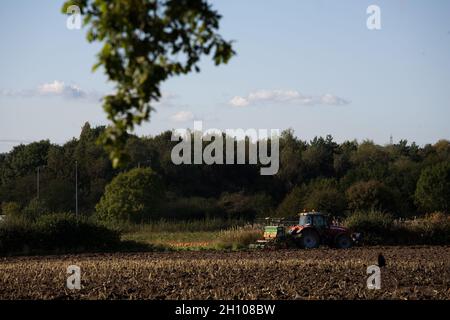 le tracteur a été mis en plan dans un champ labouré par temps ensoleillé Banque D'Images