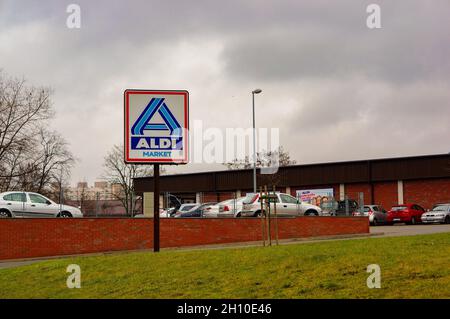 POZNAN, POLOGNE - 25 janvier 2015 : les voitures garées par Aldi marché avec un panneau en premier plan un jour sombre à Poznan, Pologne Banque D'Images