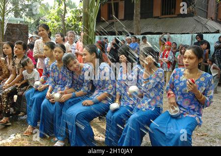 Les jeunes Rakhain, hommes et femmes, se réunissent pour jouer avec l'eau au Cox's Bazar au Bangladesh.Certaines filles sont en train de se lancer dans le jeu. Banque D'Images