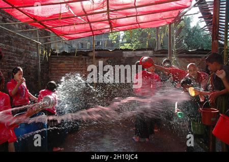 Les jeunes Rakhain les femmes et les hommes jettent de l'eau les uns sur les autres pour exprimer leur amour au Bazar de Cox au Bangladesh. Banque D'Images