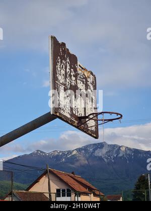 Ancien et rustique panier de basket-ball dans un village sur fond de montagne Banque D'Images