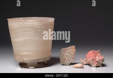 Groupe d'offre : navire, c.800-1200(?).Mexique, Guerrero(?), San Jerónimo de Juárez, style Xochicalco.Travertin ou tecali; diamètre: 18.8 x 18.4 cm (7 3/8 x 7 1/4 po); hors tout: 18.9 cm (7 7/16 po).Les objets de ce groupe, tous avec des traces de pigment rouge, auraient été trouvés ensemble, les coquilles et la plaque de pierre verte à l'intérieur de la cuve de pierre translucide.Une offrande semblable a été trouvée dans une pyramide ornée de serpents à plumes à Xochicalco, un site au sud de la vallée du Mexique. Banque D'Images