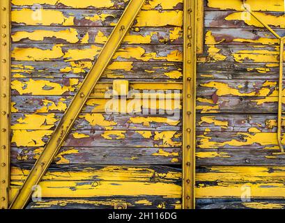 Arrière-plan de texture de wagon de train en bois pelé peint en jaune Banque D'Images