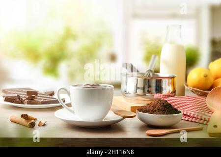 Tasse de chocolat chaud frais maison avec ingrédients sur le banc de cuisine.Vue avant. Banque D'Images