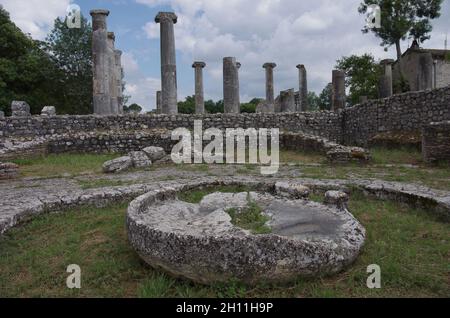 Le Macellum ou marché : au premier plan une ancienne pierre d'un moulin et en arrière-plan les colonnes de la basilique.Sepino, Molise, Italie Banque D'Images