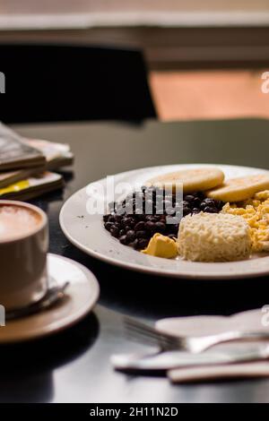 Petit déjeuner créole de type vénézuélien avec céréales, œufs brouillés et fromage blanc râpé Banque D'Images