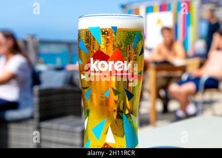 Bière cornish Korev dans un verre au Surf Beach Bar, Sennen Cove, Penwith Peninsula, Cornwall, Royaume-Uni Banque D'Images