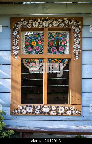 Zalipie, Pologne - 1er août 2021 : fenêtre colorée dans un chalet en bois, décoré de motifs floraux. Banque D'Images