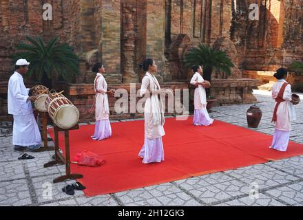 De jeunes femmes vietnamiennes accompagnées d'un batteur exécutent une danse ethnique traditionnelle à côté de l'ancien temple de po Nagar Cham, à Nha Trang, au Vietnam Banque D'Images