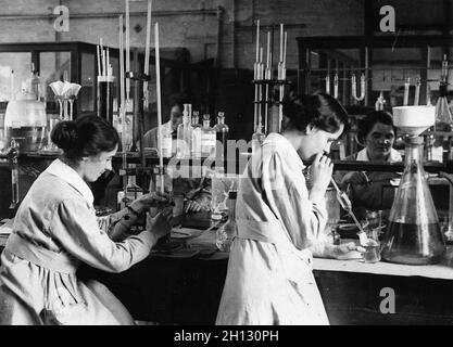 Femmes travaillant dans un laboratoire chimique dans une usine pendant la première Guerre mondiale (et la femme à droite est le pipetage à la bouche!) Banque D'Images