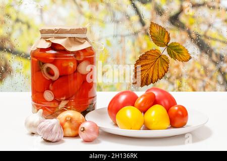 Tomates marinées dans des pots en verre sur le rebord de la fenêtre. Banque D'Images