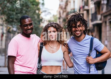 Portrait horizontal de trois amis dans les rues de Barcelone.Une femme caucasienne, un homme latino-américain et un homme afro-américain Banque D'Images