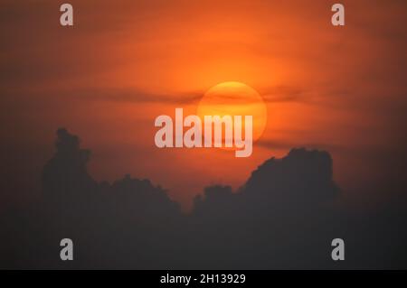 Sun disque à travers les nuages au coucher du soleil au-dessus de l'horizon.France. Banque D'Images