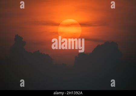 Sun disque à travers les nuages au coucher du soleil au-dessus de l'horizon.France. Banque D'Images