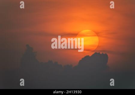 Sun disque à travers les nuages au coucher du soleil au-dessus de l'horizon.France. Banque D'Images