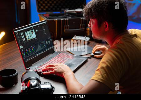 Un homme éditeur vidéo travaille avec des séquences sur son ordinateur personnel, il travaille dans un studio de bureau créatif.Réalisation de films.Réalisation de films d'équipement.Créer des vidéos. Banque D'Images