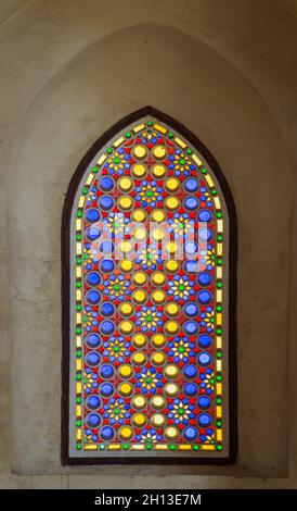 Fenêtre en stuc perforé décorée de verre coloré avec des motifs circulaires géométriques et des motifs floraux, située dans le complexe historique public de l'ère Mamluk, rue Moez, le Caire, Egypte Banque D'Images