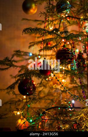 Nouvel an ou Noël en direct décoré avec élégance en épicéa gros plan - Jouets du nouvel an sur fond de branches vertes et feux Banque D'Images