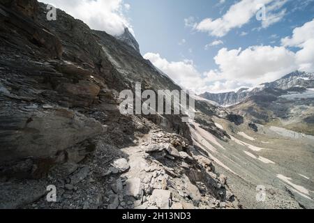 Vue sur le sentier de randonnée alpin jusqu'au gîte Hoernli "Hörnlihütte", près de zermatt en suisse, la cabane est au pied du cervin. Banque D'Images