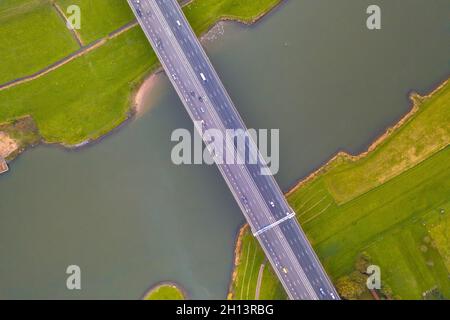 Vue aérienne de dessus en bas de l'immense rivière des basses terres IJssel avec pont de l'autoroute à travers le paysage agricole. Zwolle, province d'Overijssel, pays-Bas. Dr Banque D'Images