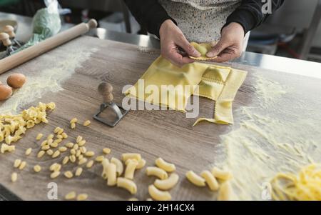 Gros plan sur les mains des femmes préparant des raviolis frais faits maison Banque D'Images