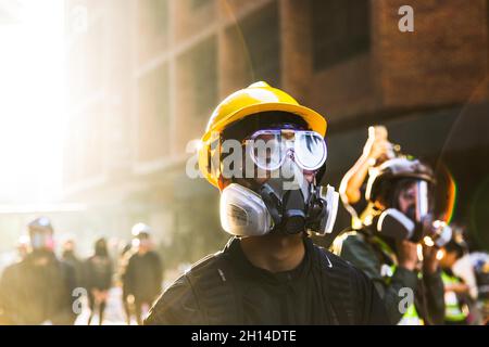 Le 18 novembre 2019, Hong Kong, Chine : un manifestant portant un masque à gaz et un casque pendant la manifestation. De nombreuses manifestations massives ont éclaté à Hong Kong en 2019, alors que le projet de loi d'extradition soulève de sérieuses préoccupations quant au fait que les autorités de Hong Kong peuvent renvoyer le défendeur non condamné en Chine,C'était l'une des plus grandes critiques civiles après la remise de Hong Kong en Chine en 1997.Les manifestations se sont rapidement multipliées à la suite de manifestations pacifiques, pour se transformer en affrontements violents avec la police en juillet.Des milliers de personnes arrêtées, blessées et aujourd'hui derrière les barreaux, alors que la vague principale d'affrontements se termine en novembre dernier Banque D'Images