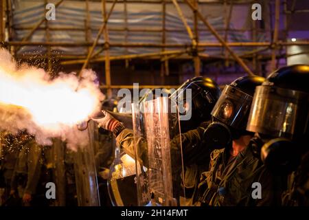 La police utilise du gaz de tarage pour disperser les manifestants pendant la manifestation.de nombreuses manifestations massives ont éclaté à Hong Kong en 2019, alors que le projet de loi d'extradition soulève de sérieuses inquiétudes car les autorités de Hong Kong peuvent renvoyer le défendeur non condamné en Chine,C'était l'une des plus grandes critiques civiles après la remise de Hong Kong en Chine en 1997.Les manifestations se sont rapidement multipliées à la suite de manifestations pacifiques, pour se transformer en affrontements violents avec la police en juillet.Des milliers de personnes arrêtées, blessées et aujourd'hui derrière les barreaux, alors que la vague principale d'affrontements se termine en novembre lors des sièges dans les universités.Juin 2020 Banque D'Images