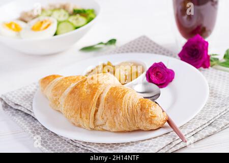 Petit déjeuner porridge de flocons d'avoine avec œufs durs, concombre et croissant, confiture, café.Une alimentation saine et équilibrée. Banque D'Images