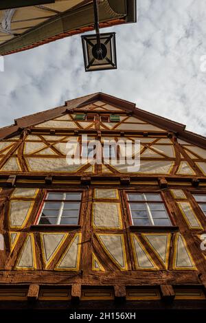 Photo à angle bas d'une ancienne maison à pans de bois en Allemagne avec un lampadaire sous un ciel nuageux Banque D'Images