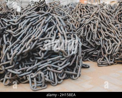 Chaînes de liaison rondes en acier pour le transport et l'élévation de l'équipement et des systèmes repliés en tas.Des piles de chaînes à l'extérieur Banque D'Images