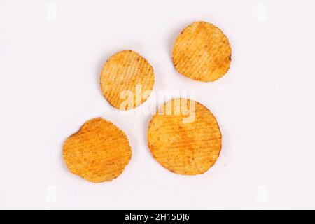 Croustilles de pommes de terre entrant dans bol en verre isolé sur fond blanc avec chemin de détourage, battant les chips de pommes de terre Banque D'Images