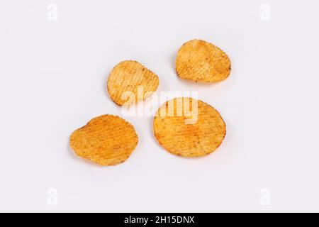 Croustilles de pommes de terre entrant dans bol en verre isolé sur fond blanc avec chemin de détourage, battant les chips de pommes de terre Banque D'Images