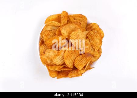 Croustilles de pommes de terre entrant dans bol en verre isolé sur fond blanc avec chemin de détourage, battant les chips de pommes de terre Banque D'Images