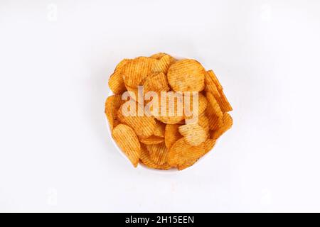 Croustilles de pommes de terre entrant dans bol en verre isolé sur fond blanc avec chemin de détourage, battant les chips de pommes de terre Banque D'Images
