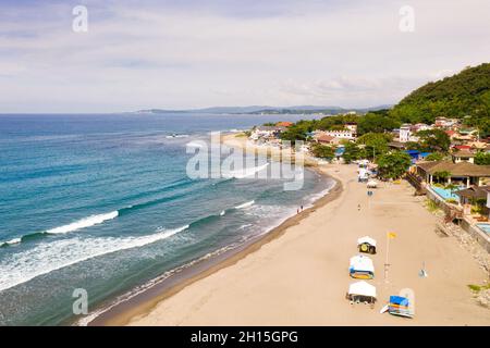 Côte sablonneuse, bâtiments et mer bleue avec vagues.San Juan, la Union, Philippines.Ville côtière avec une plage de surfeurs.Les plages de l'île des Philippines Banque D'Images