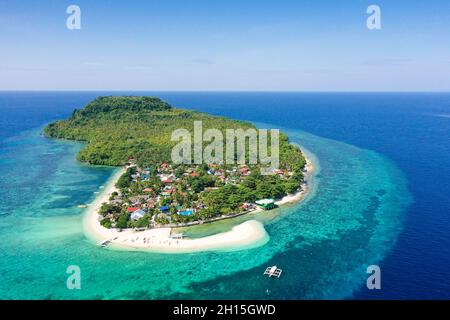 Himokilan Island, Leyte Island, Philippines. Île tropicale avec un village et une plage blanche. Eaux turquoise et récifs coralliens autour de l'île. Somme Banque D'Images