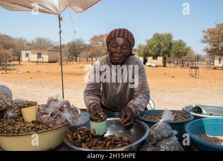 Vendeurs de rue africains sur la route vendant des arachides brutes, du maïs, des oranges de singe et des vers de mopane, Banque D'Images