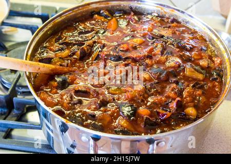 Faire de la confiture de prunes : cuire des prunes hachées dans une casserole métallique sur une cuisinière à gaz Banque D'Images
