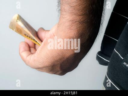 L'homme tient l'argent en main.Recevoir des pots-de-vin, de l'argent noir, de la récupération, des bénéfices. Gros plan.Mouvement sur fond blanc isolé Banque D'Images