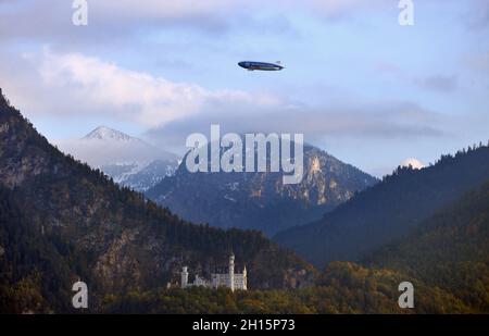 16 octobre 2021, Bavière, Füssen: Un zeppelin survole le château de Neuschwanstein à l'occasion de la première mondiale de la comédie musicale 'Zeppelin'.Photo : Karl-Josef Hildenbrand/dpa Banque D'Images